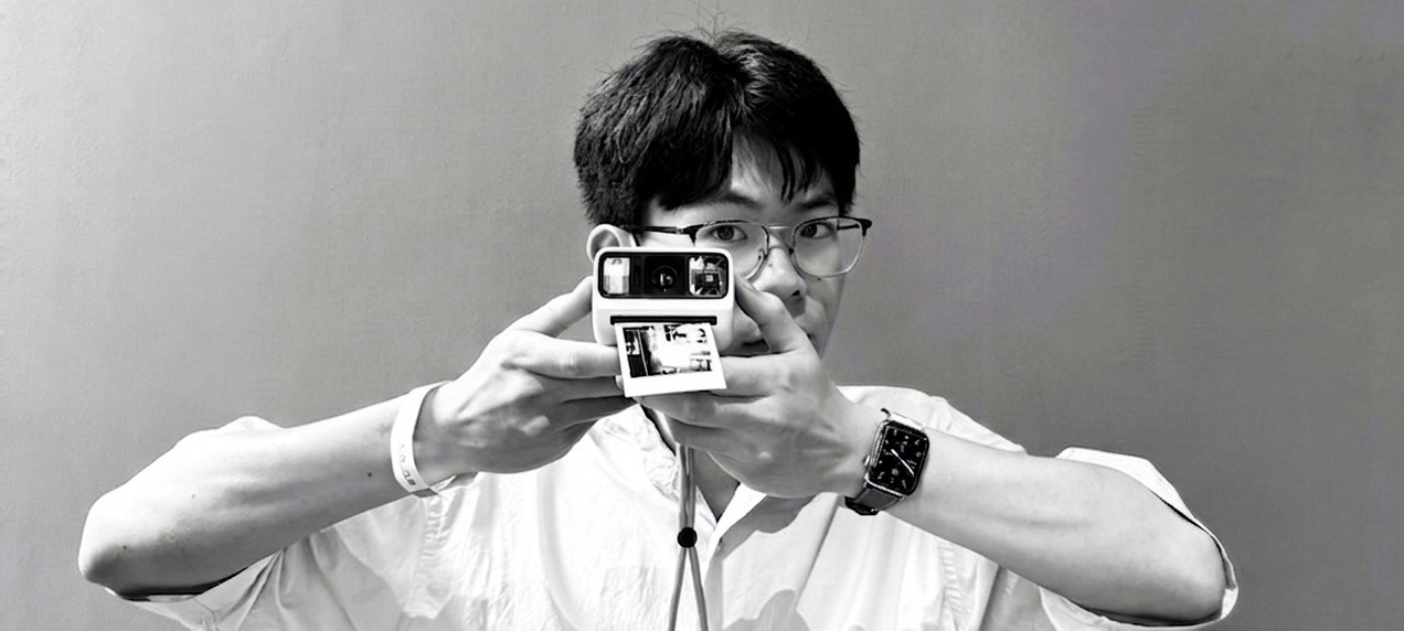 Mirror self-portrait on film — face hidden behind a Hasselblad